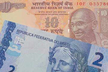 A macro image of a orange ten rupee bill from India paired up with a blue two real bank note from Brazil.  Shot close up in macro.