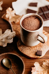 Close-up of hot chocolate in a ceramic mug on the table. Autumn or winter cozy still life.