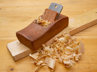 wooden hand plane with sawdust on the board