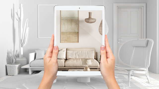 Hands holding tablet showing cosy living room with sofa, total blank project background, augmented reality concept, application to simulate furniture and interior design products