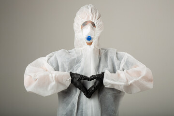 woman in protective medical suit wearing mask and gloves with hand gesture