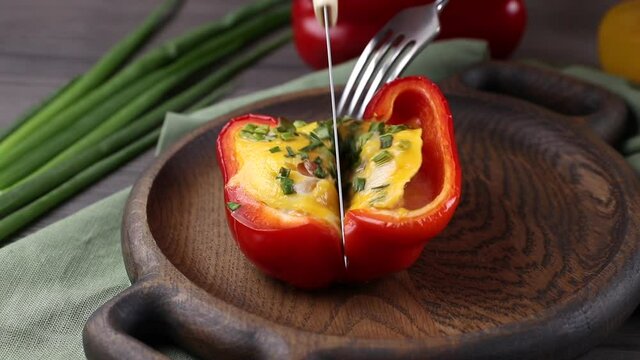 cutting by knife stuffed red bell pepper close-up. served table at lunch