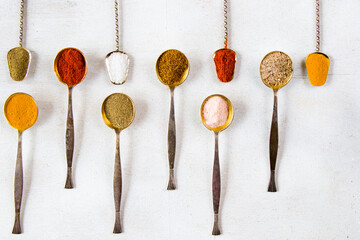 variation of spices on the vintage silver spoons, all spices on the table