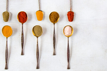 variation of spices on the vintage silver spoons, all spices on the table