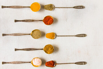 variation of spices on the vintage silver spoons, all spices on the table
