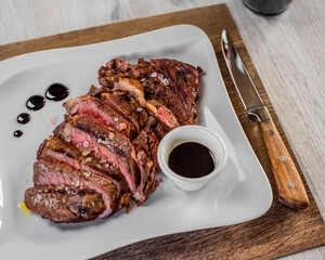 Tagliata di controfiletto cotta al sangue servita con salsa barbecue fatta in casa