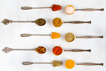 variation of spices on the vintage silver spoons, all spices on the table