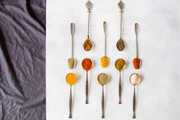 variation of spices on the vintage silver spoons, all spices on the table