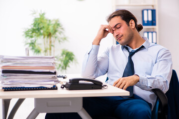 Naklejka premium Young male employee unhappy with excessive work