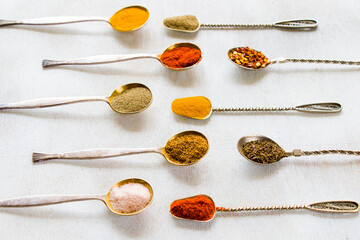 variation of spices on the vintage silver spoons, all spices on the table