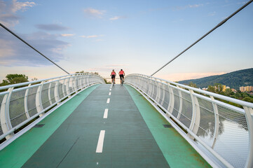 Bicycle riders riding on bicycle bridge (called “Freedom bridge”) connecting two countries Slovakia and Austria (Bratislava, SLOVAKIA)