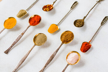 variation of spices on the vintage silver spoons, all spices on the table