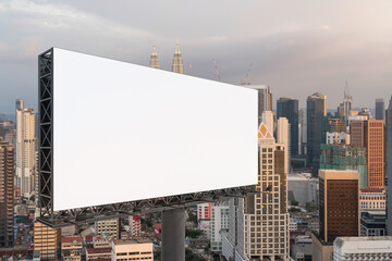 Blank white road billboard with Kuala Lumpur cityscape background at sunset. Street advertising poster, mock up, 3D rendering. Side view.