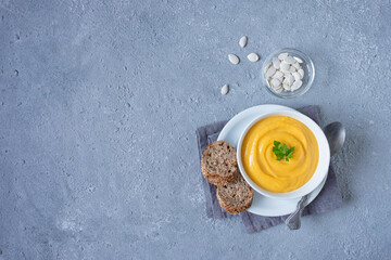 Pumpkin soup on a gray stone background. Space for copying. The view from the top.