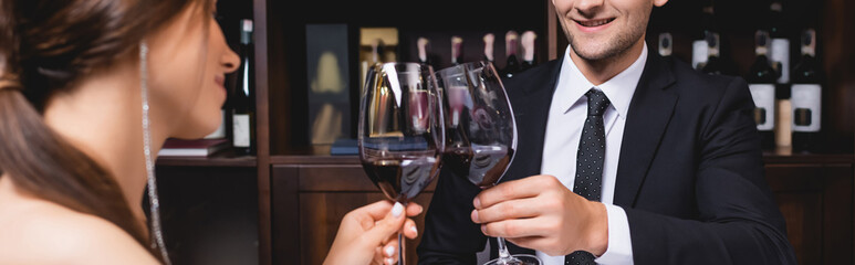 Panoramic crop of couple toasting with wine in restaurant