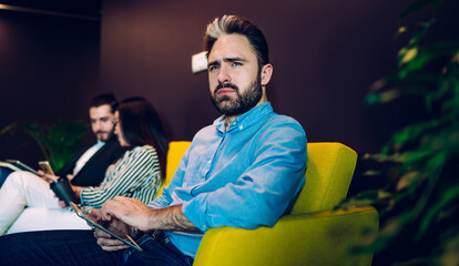 Thoughtful businessman sitting in office lounge