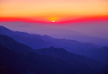 Obraz premium Majestic mountain landscape with silhouettes of mountain ridges at sunset