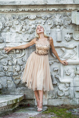 Young beautiful blonde girl in beige dress