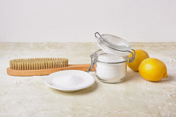 citric acid, soda, lemons and a wooden brush on a light background for eco cleaning, natural and...