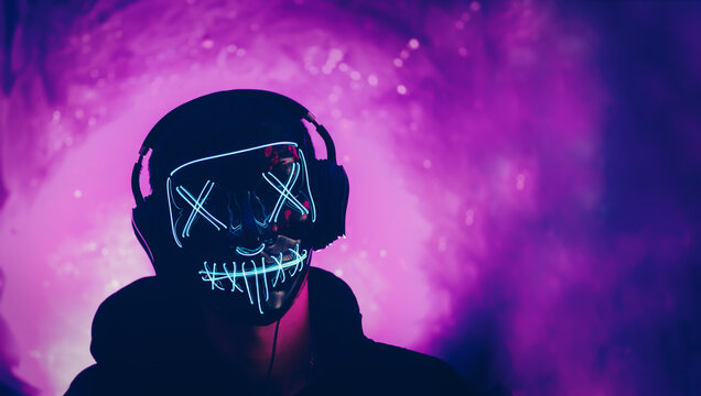 Autumn Halloween Party, Incognito Wearing Headphones And A Glowing Mask On A Neon Purple Background