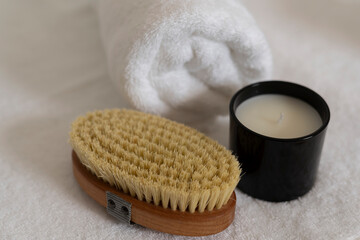 Body brushing, towel and a candle