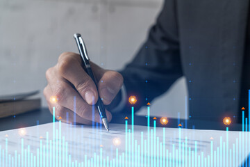 Businessman in suit signs contract. Double exposure with financial chart hologram. Man signing mortgage agreement. Real estate market analysis and investment concept.