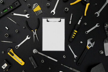 Notebook for writing, around various work tools on a black background.