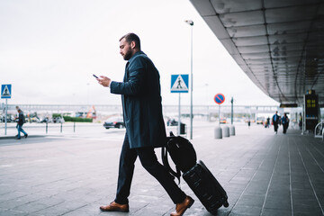 Caucasian passenger checking electronic ticket with info about terminal departure using modern...