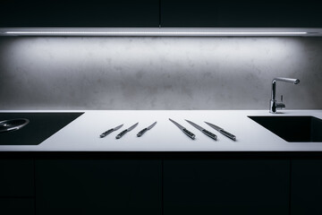 White kitchen worktop with concrete spatula on wall and illuminated LED strip in ceiling. There is...
