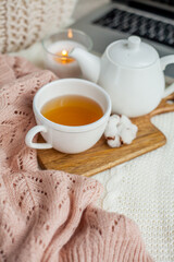 Laptop, hot tea mug, candle, glasses, kettle, wooden stand. Quarantine. Home Office. Cozy breakfast. Fall.