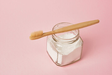 bamboo toothbrush and soda can on pink background