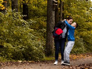 son hugs mother for a walk in the Park. the yellow foliage. autumn. mother's love for the child