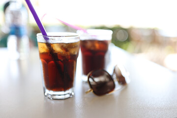Table two dark colored cocktails with straw. Refreshing drinks in summer concept