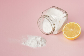 lemon and soda spilled from a glass jar on a pink background