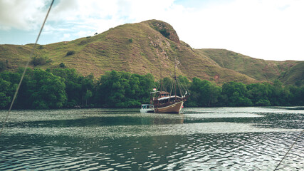fishing boafishing boat on the lake, leisure and travel concept, beautiful sea bay with hills and...