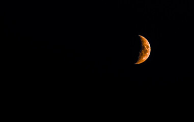 Blood moon or hunters moon rising on a pitch black night sky.