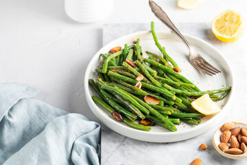 green string beans in spices, lemon, on a white background