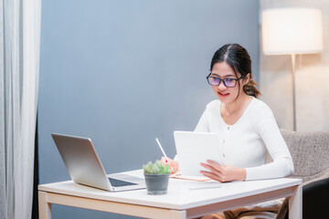 Asian attractive student girl happy smiling at home studying abroad online internet communication video call using computer laptop with typing information taking notes on keyboard learning educational