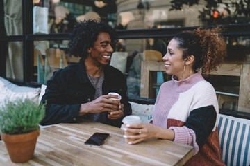 Young diverse couple drinking coffee in modern cafe