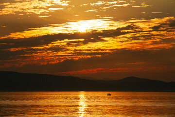 A single boat on Lake Champlain at sunset