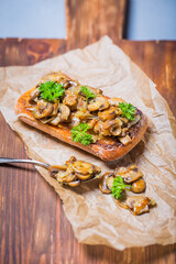 grilled ciabatta sandwich with mushrooms and feta cheese on a wooden board