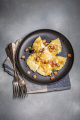 Dumplings with meat, onions and bacon on black plate. Traditional Polish dumplings