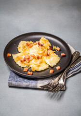 Dumplings with meat, onions and bacon on black plate. Traditional Polish dumplings