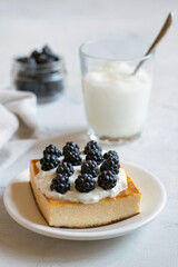 Delicious homemade cheesecake on a plate with blackberries and yogurt. Baking from cottage cheese. A curd casserole. Selective focus.