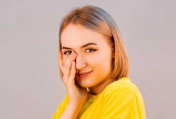 Smiling woman look forward hand near face isolated on gray background