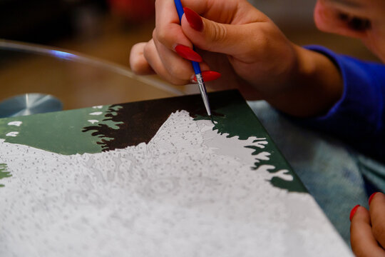 Picture by numbers. Drawing on canvas. Woman's hand with brush. Selective focus. Close up.