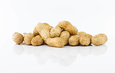 Heap of unpeeled peanuts on white background.
