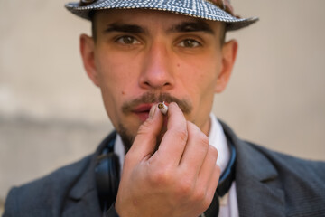 Portrait of the man with real rolled marijuana or cannabis cigarette. Selective focus.