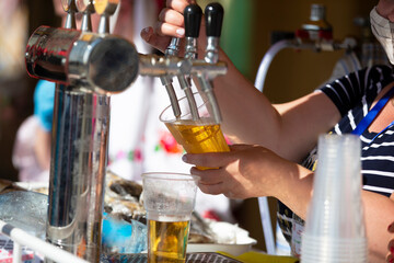 The seller's hands pour the beer. Draft beer.