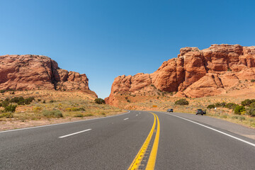 Fototapeta na wymiar Roadtripping through Arizona on the highway running between two giant red rock bluffs